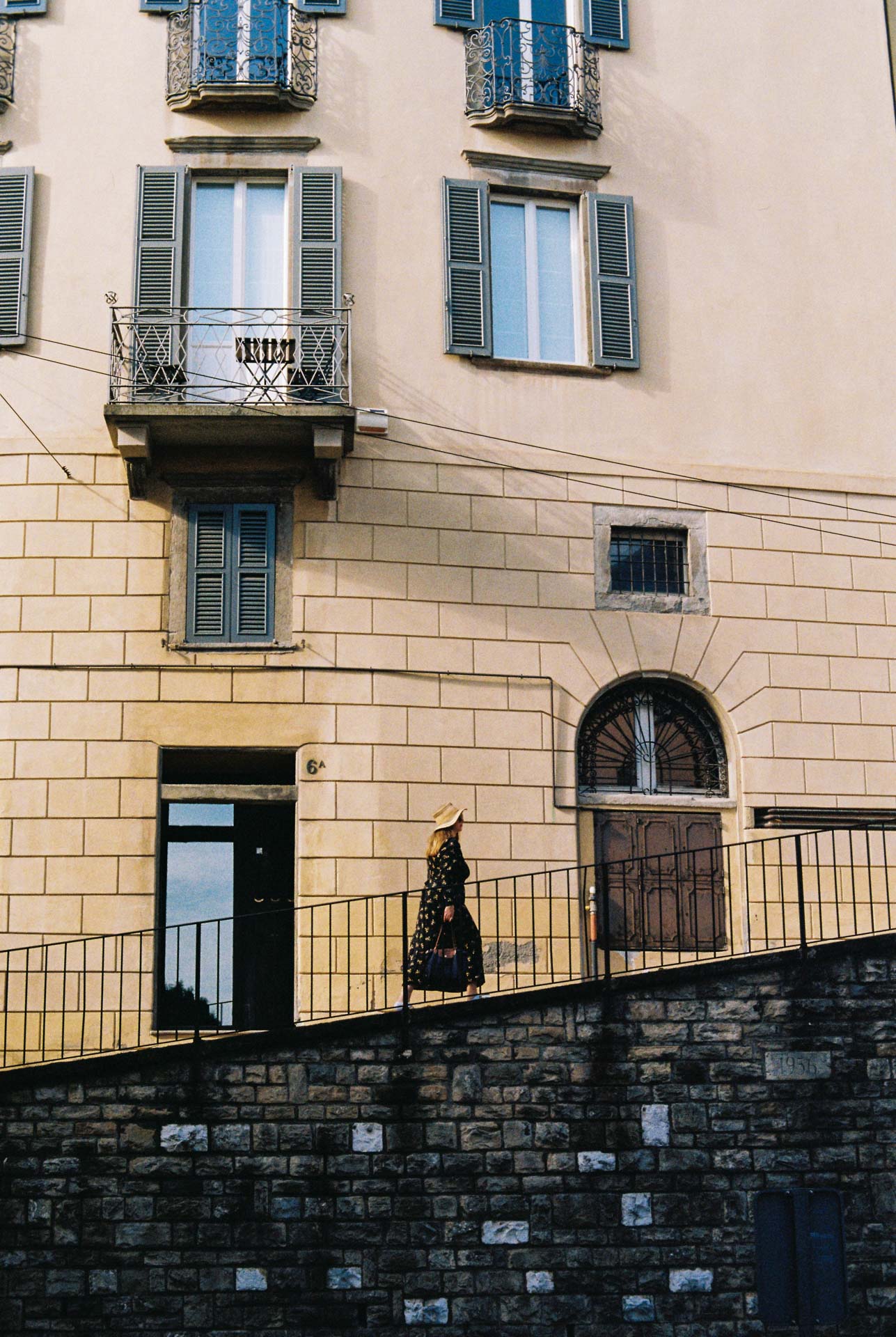 A woman walks up a street in the citta alta, Bergamo, Italy taken on Kodak Gold 200 film stock.