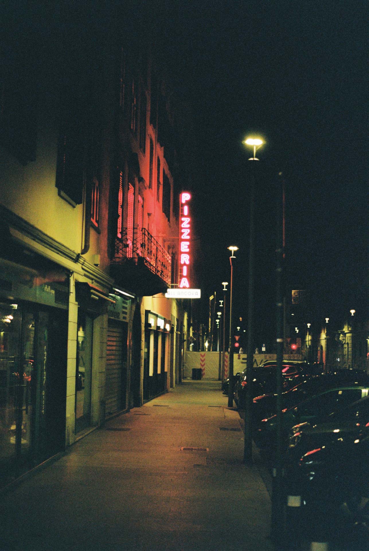 A neon pizzeria sign taken at night in Bergamo, Italy on Kodak Gold 200 film stock.