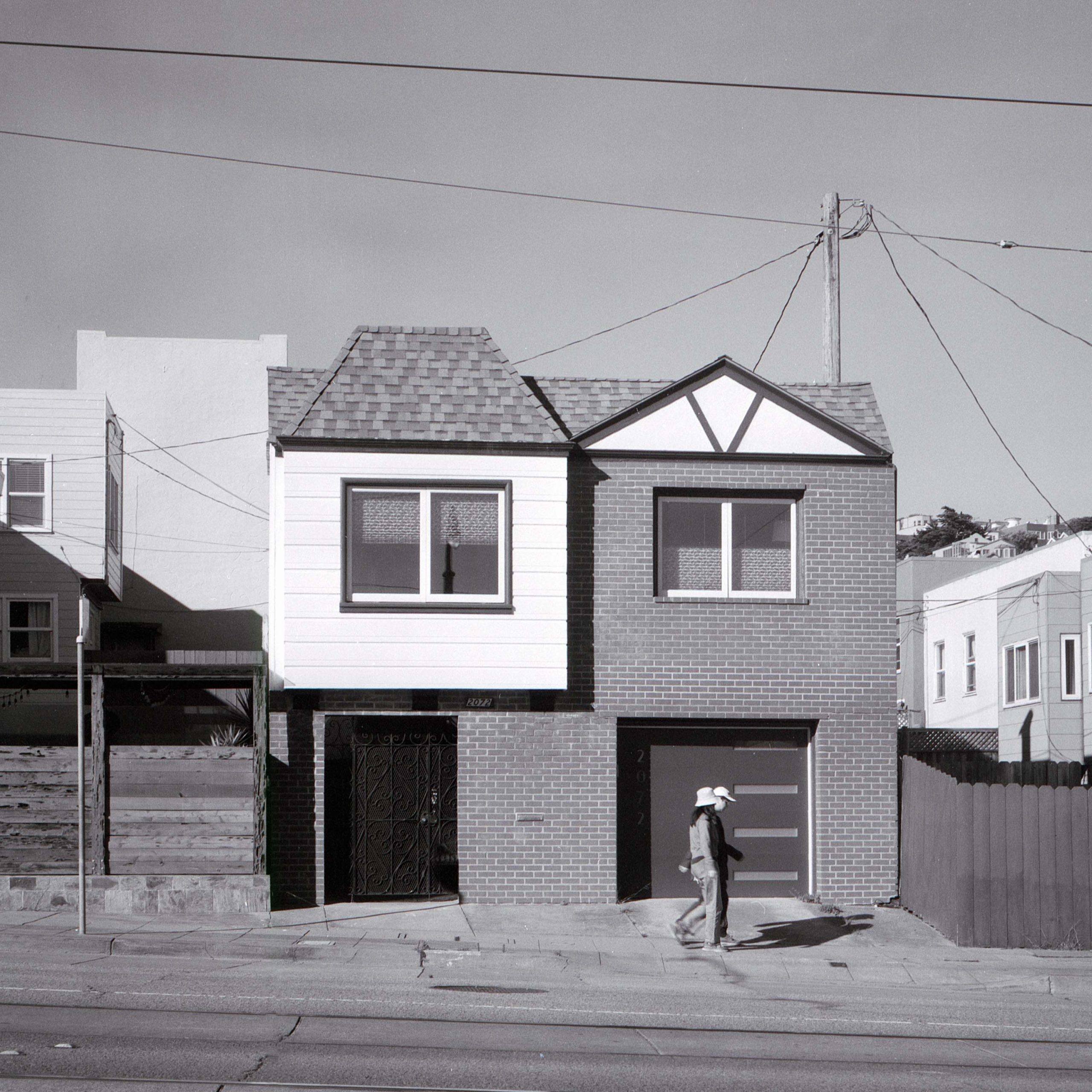 A couple walk past a house in San Francisco