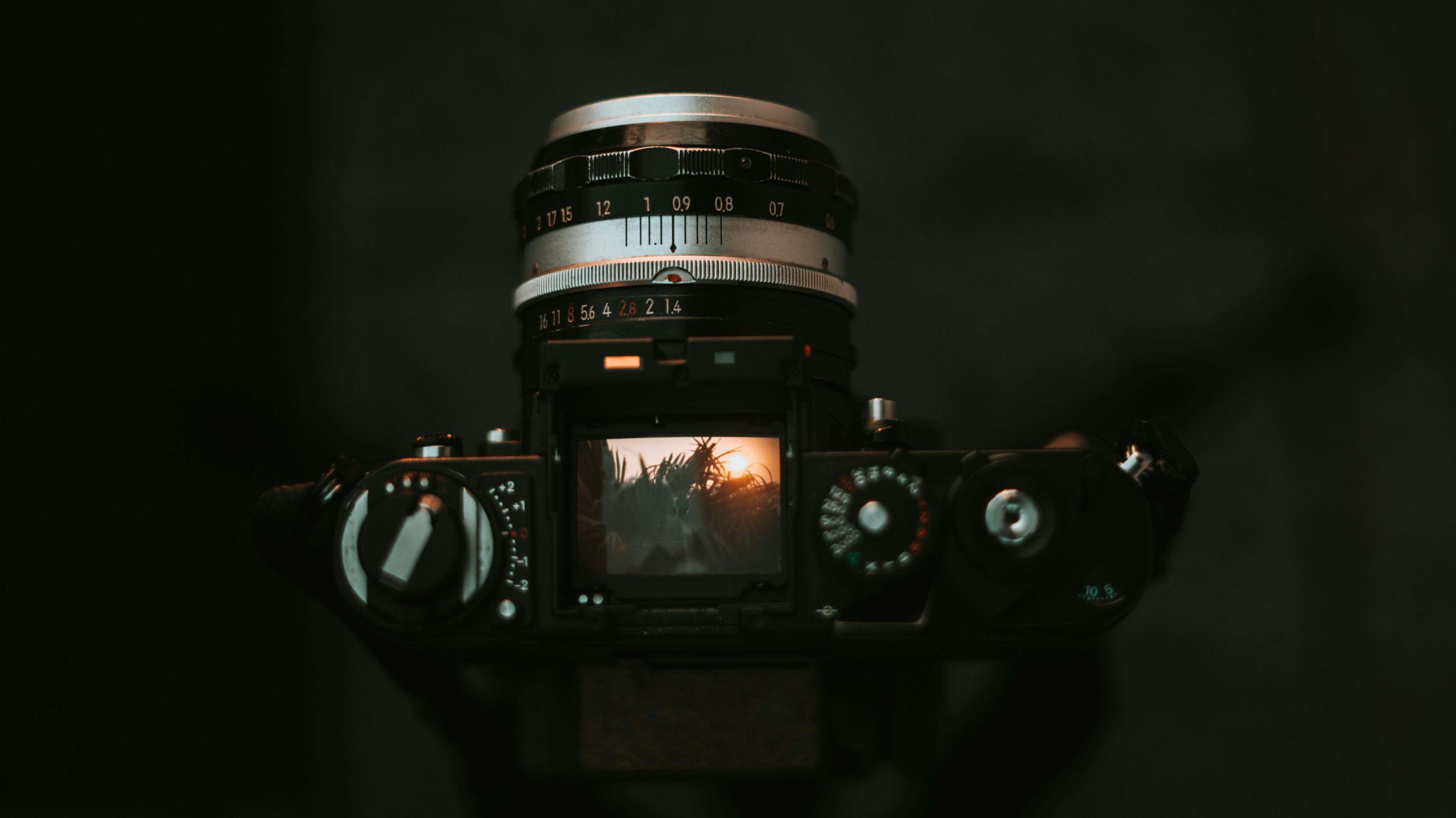 A black film camera showing a viewfinder and manual controls.