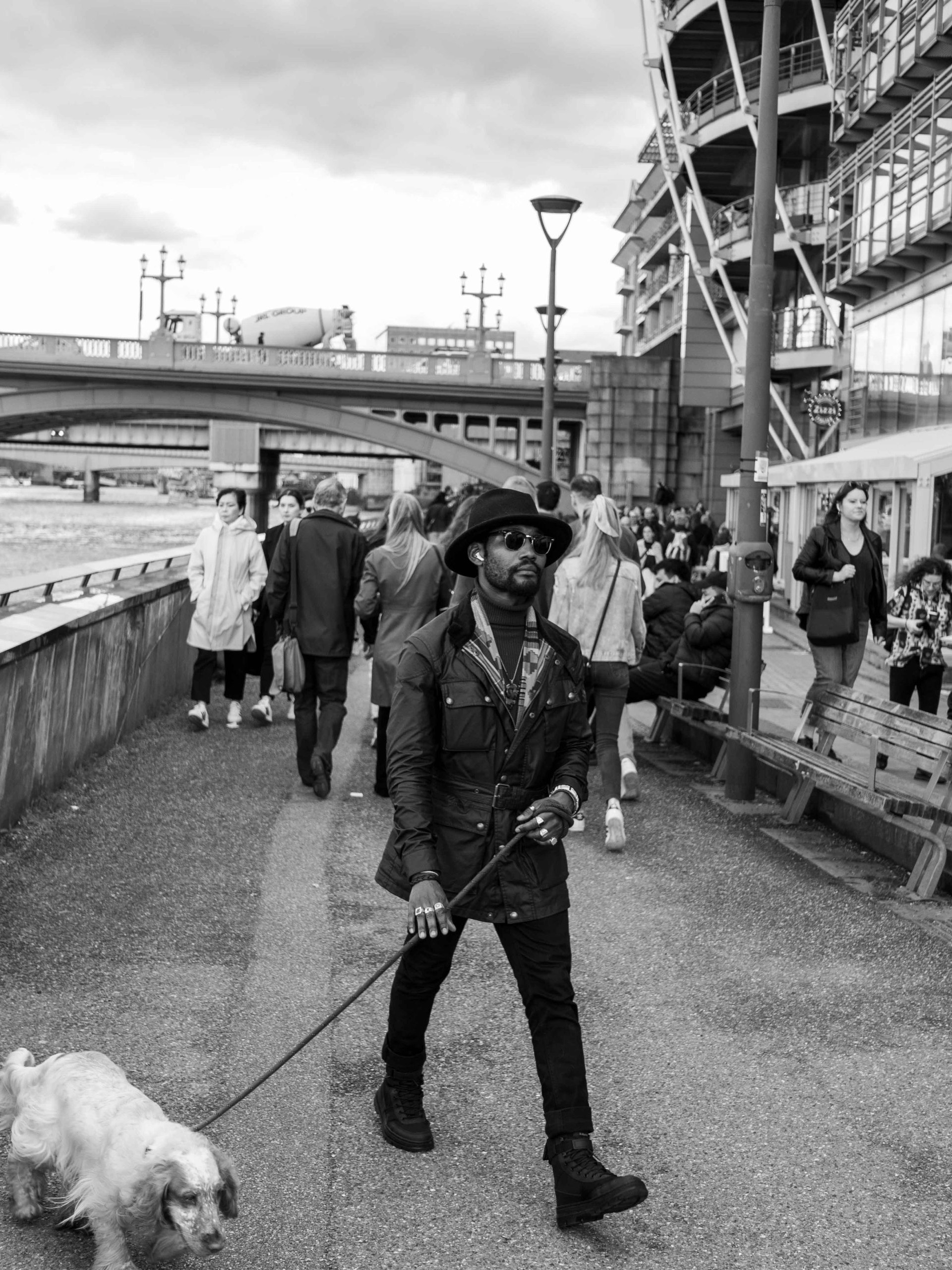 A well dressed man walks his dog through London