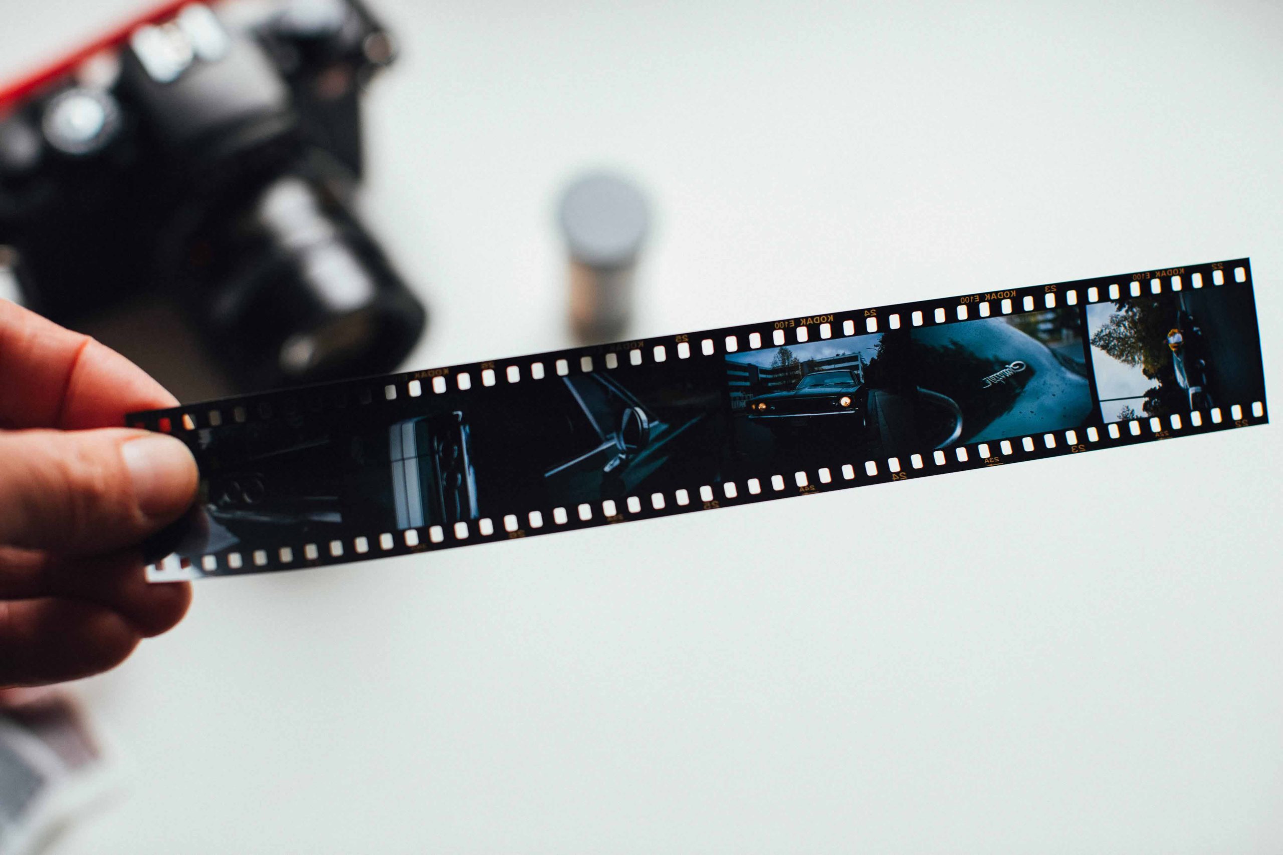 A person holding a roll of film showing the negative exposures.